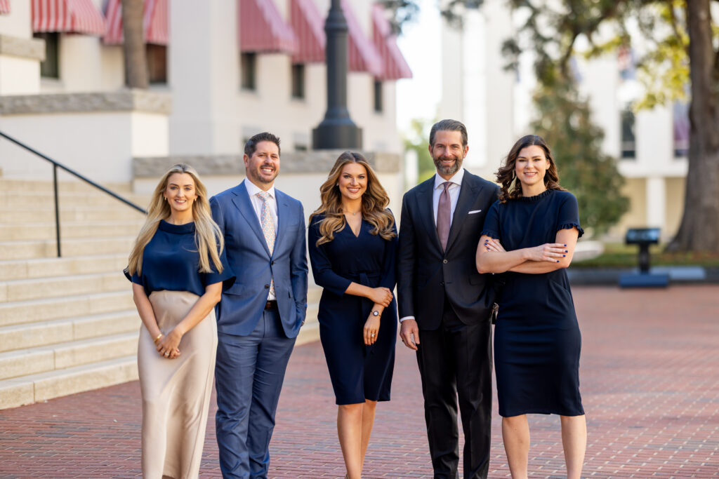 Five Capital City Consulting lobbyists standing on a brick plaza in downtown Tallahassee