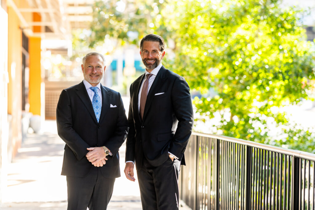 Two Capital City Consulting partners in suits standing outside an office building